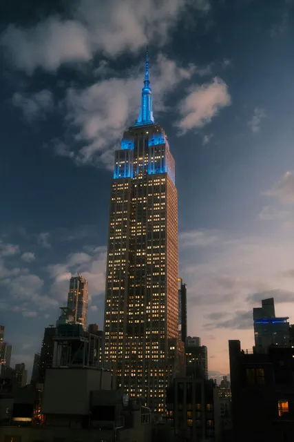 A vertical dusk cityscape establishing shot capturing the Empire State Building 