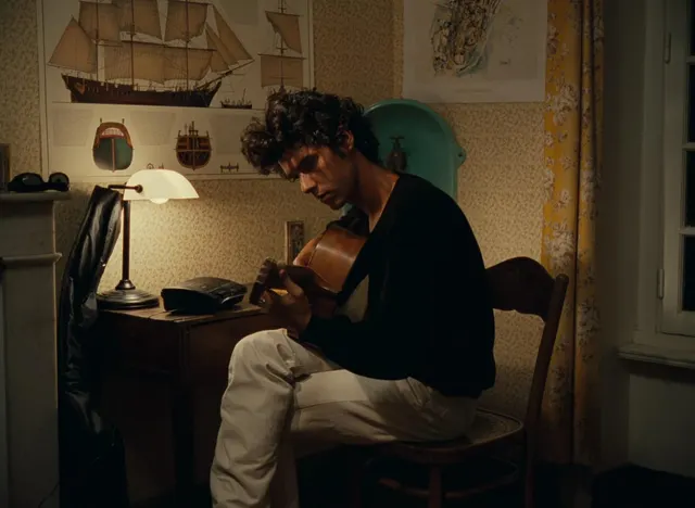 This shot captures an intimate moment of a musician engrossed in playing his gui