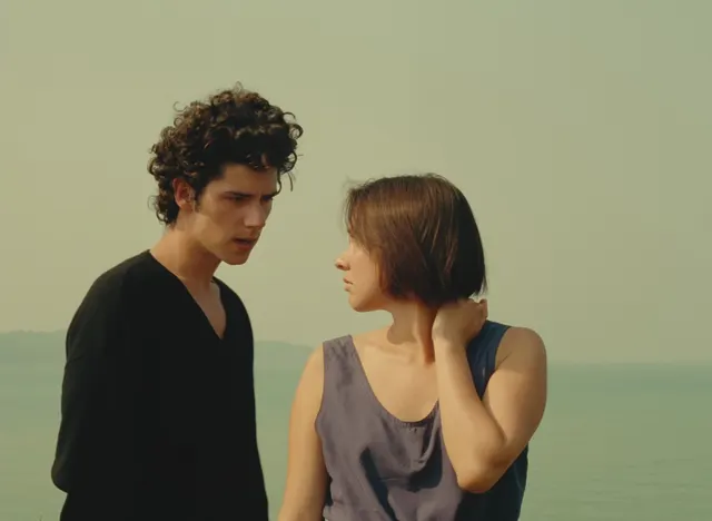 This is a two-shot of a man and a woman in a quiet, contemplative moment, framed